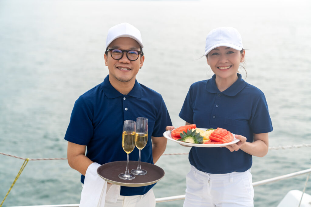 Crew serving chilled champagne and fresh fruit on deck — what an all-inclusive rate or the APA pays for