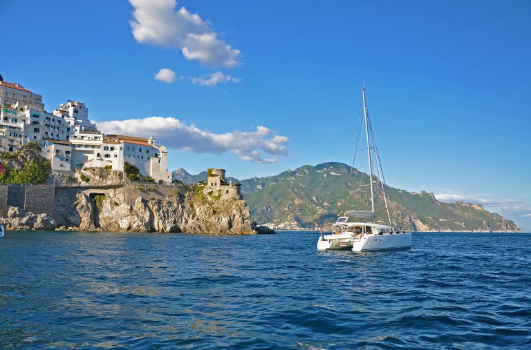 Amalfi from the water, with a white yacht at anchor below the town