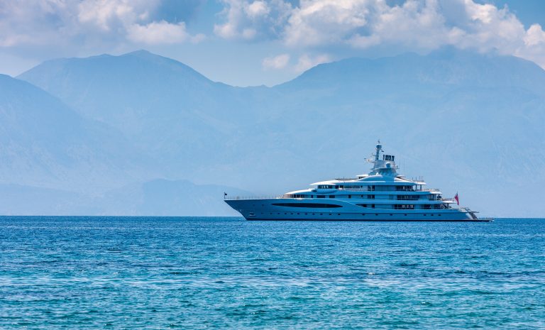 A large white superyacht under way off the coast of Crete