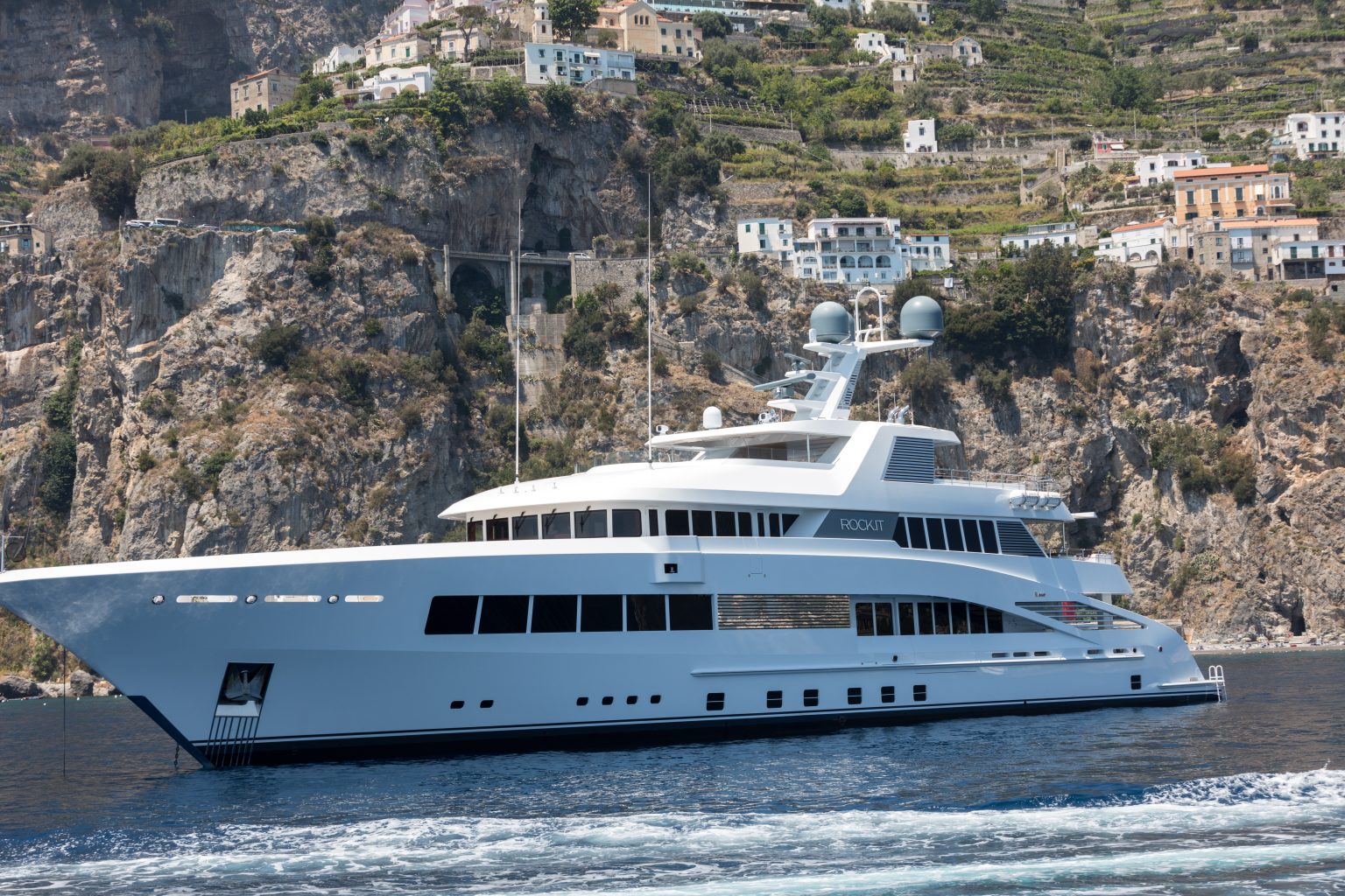 A crewed motor yacht under way off Positano on the Amalfi Coast