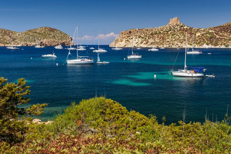 Yachts on mooring buoys in the bay of Cabrera, below the old castle